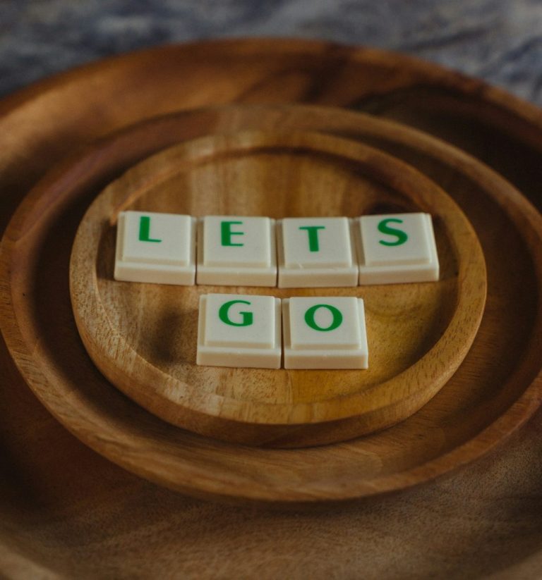 Lettres blanches sur fond en bois, formant l'expression "LETS GO".